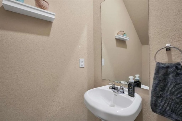 157 Oliver Dr, Locust Grove, GA 30248 - bathroom with a sink, a textured wall, and vaulted ceiling