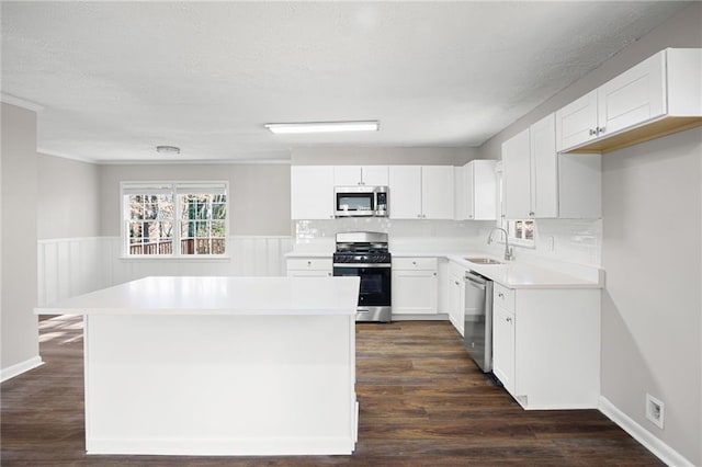 kitchen featuring appliances with stainless steel finishes, sink, white cabinets, and dark hardwood / wood-style flooring