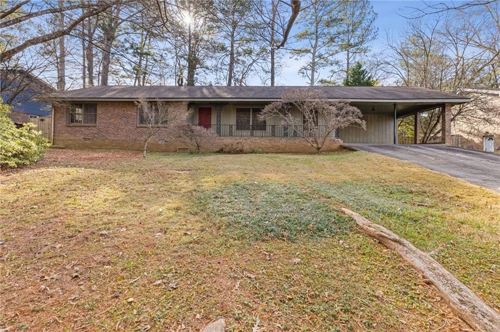 single story home with covered porch, a front lawn, and a carport