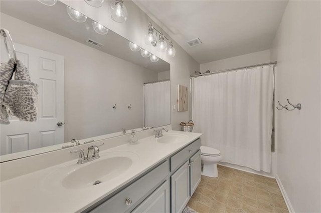 full bath with visible vents, a sink, toilet, and double vanity