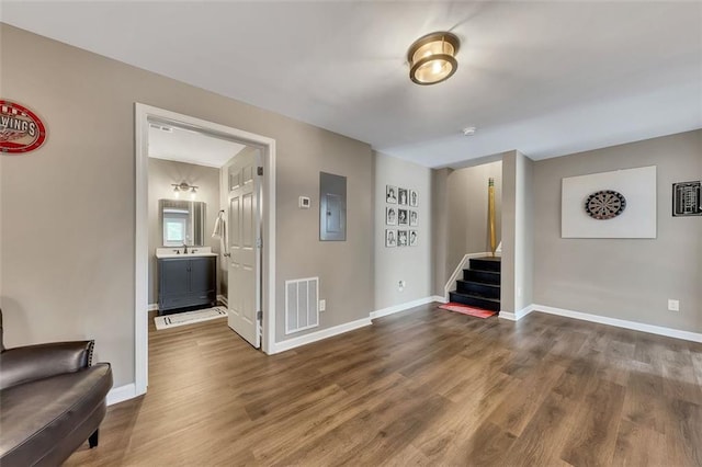 interior space with visible vents, stairway, dark wood-type flooring, electric panel, and baseboards