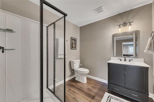 bathroom featuring visible vents, a shower stall, toilet, and wood finished floors