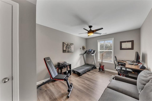 exercise room featuring ceiling fan, baseboards, and wood finished floors