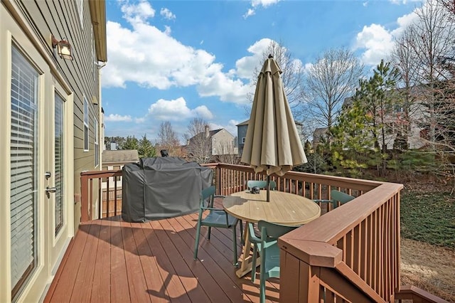 wooden terrace with outdoor dining area and grilling area