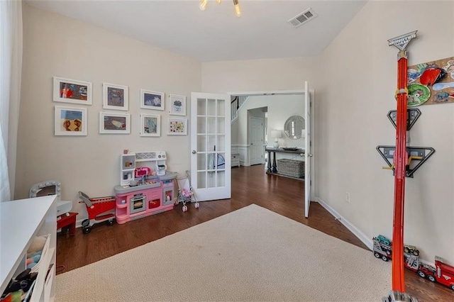 rec room featuring dark wood-style floors, french doors, visible vents, and baseboards