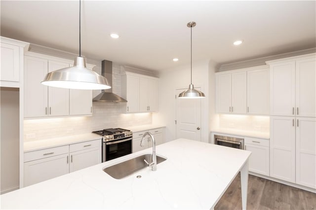 706 Dodd Ln Unit 157, Buford, GA 30518 - kitchen featuring wall chimney range hood, stainless steel appliances, a sink, white cabinets, and tasteful backsplash