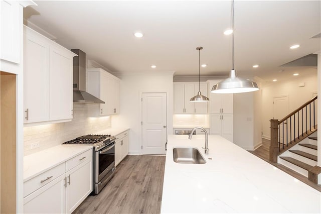 706 Dodd Ln Unit 157, Buford, GA 30518 - kitchen with gas stove, wall chimney exhaust hood, a sink, white cabinets, and recessed lighting