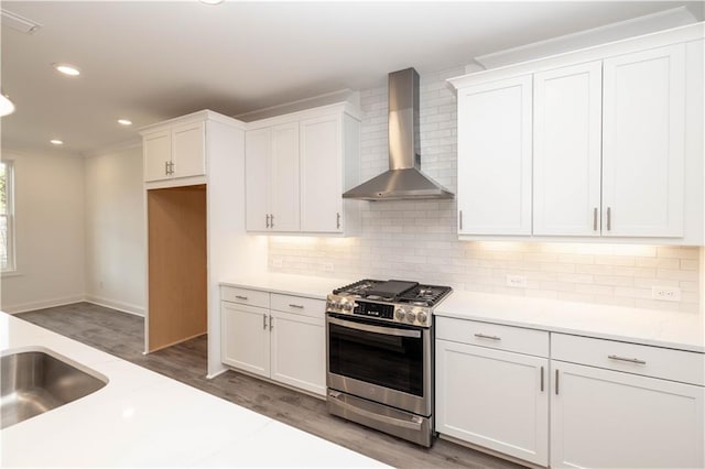 706 Dodd Ln Unit 157, Buford, GA 30518 - kitchen featuring wall chimney range hood, stainless steel gas stove, wood finished floors, white cabinets, and recessed lighting