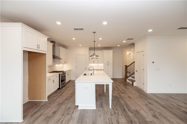 706 Dodd Ln Unit 157, Buford, GA 30518 - kitchen with gas range, wall chimney range hood, a sink, tasteful backsplash, and a kitchen island with sink