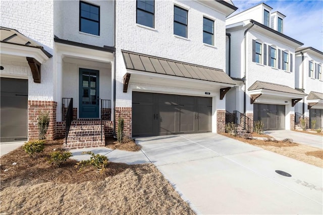 706 Dodd Ln Unit 157, Buford, GA 30518 - view of front of home featuring brick siding, a standing seam roof, a garage, concrete driveway, and metal roof