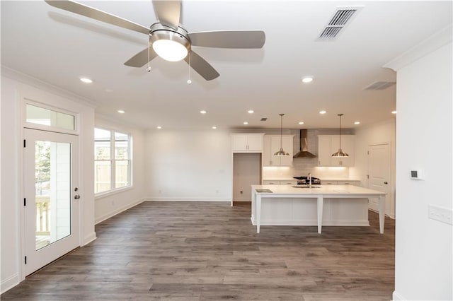 706 Dodd Ln Unit 157, Buford, GA 30518 - kitchen with wall chimney exhaust hood, a breakfast bar, white cabinets, wood finished floors, and light countertops