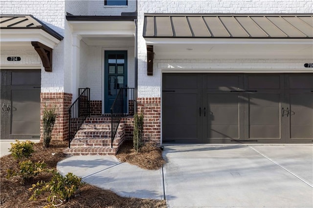 706 Dodd Ln Unit 157, Buford, GA 30518 - doorway to property with brick siding, a garage, driveway, and a standing seam roof