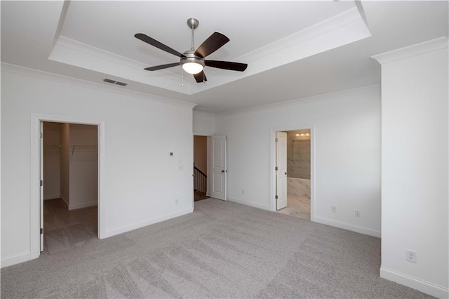 706 Dodd Ln Unit 157, Buford, GA 30518 - unfurnished bedroom featuring a tray ceiling, crown molding, a spacious closet, carpet, and baseboards