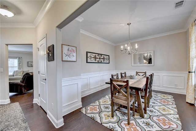 dining area with crown molding, dark hardwood / wood-style floors, and a chandelier