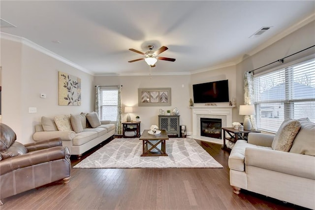 living room with crown molding, dark hardwood / wood-style floors, and a healthy amount of sunlight