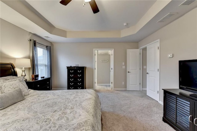 bedroom featuring carpet, a raised ceiling, and ceiling fan