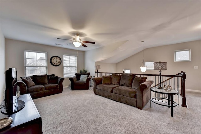 carpeted living room with ceiling fan with notable chandelier and vaulted ceiling