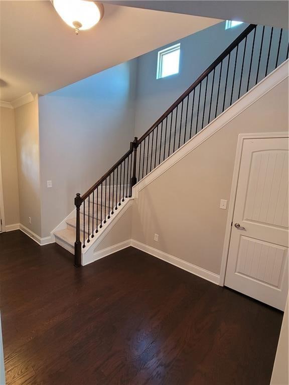 staircase featuring crown molding and wood-type flooring