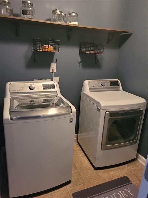 laundry room featuring washing machine and dryer and light tile patterned floors