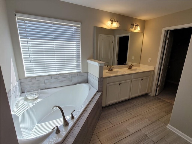 bathroom featuring vanity and tiled bath