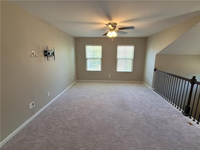 empty room with ceiling fan and light colored carpet