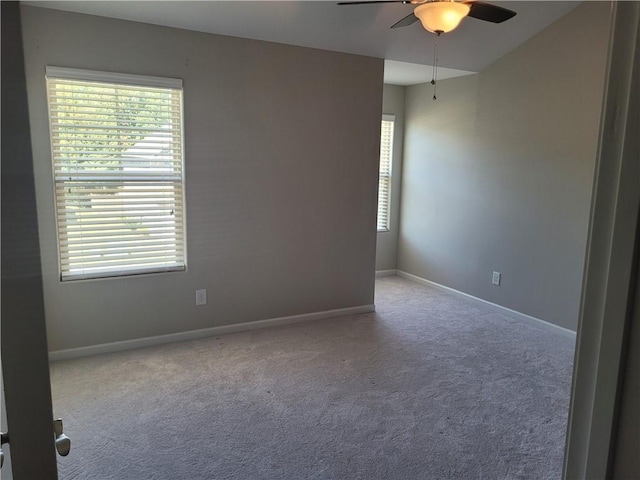 spare room with ceiling fan and light colored carpet