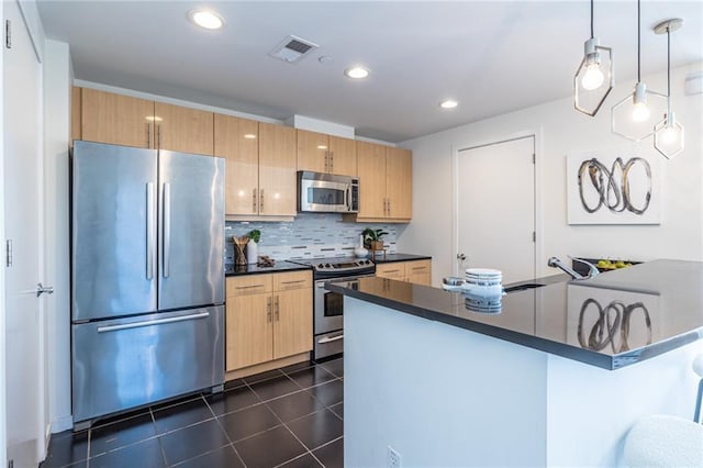 kitchen featuring dark tile patterned flooring, a kitchen breakfast bar, hanging light fixtures, decorative backsplash, and stainless steel appliances