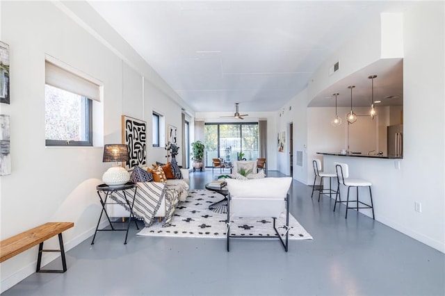 living room featuring ceiling fan and concrete flooring