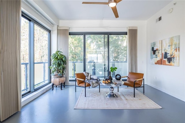 sitting room with concrete flooring and ceiling fan