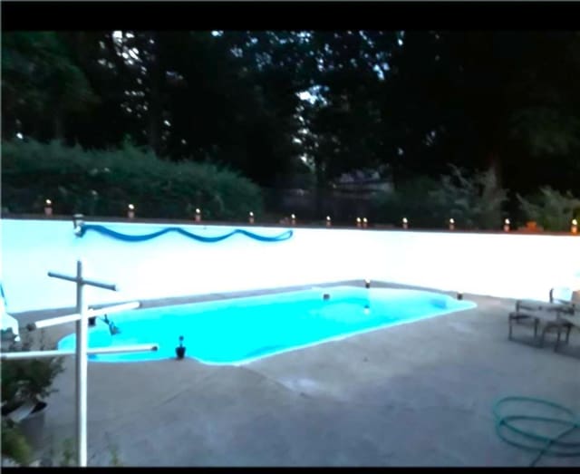 pool featuring fence and a patio area