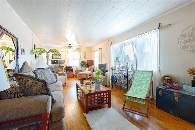 living room with a ceiling fan, wood finished floors, and crown molding