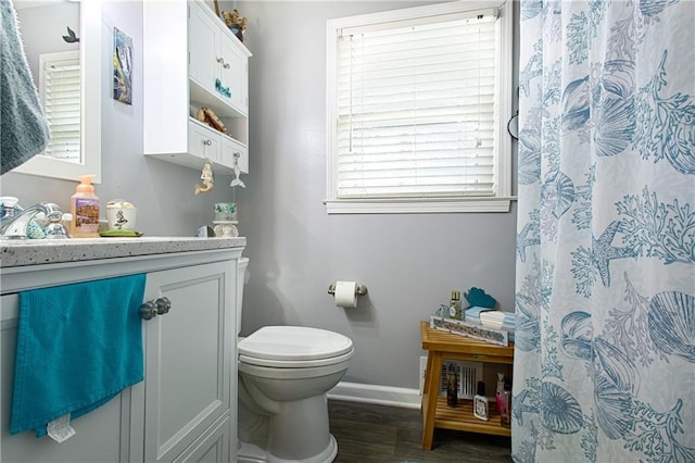 bathroom with a shower with curtain, toilet, wood finished floors, baseboards, and vanity