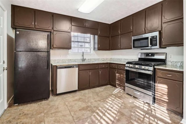 kitchen with dark brown cabinets, sink, and appliances with stainless steel finishes