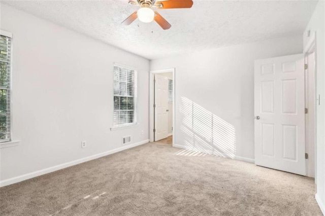 spare room featuring ceiling fan and light colored carpet