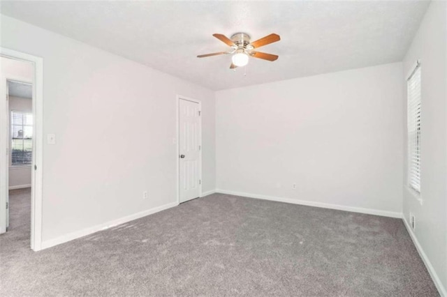 carpeted spare room featuring ceiling fan