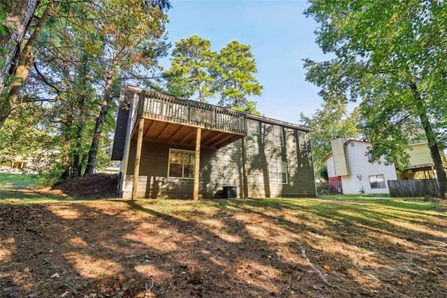 back of house with a deck and a yard