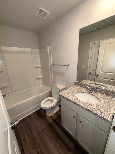 30 Barton Ln, Covington, GA 30016 - bathroom featuring vanity, wood finished floors, toilet, and bathtub / shower combination