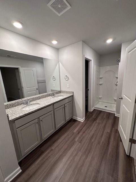 30 Barton Ln, Covington, GA 30016 - bathroom featuring baseboards, wood finished floors, a stall shower, double vanity, and recessed lighting