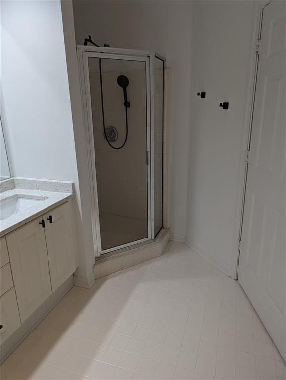 bathroom with tile patterned flooring, vanity, and an enclosed shower