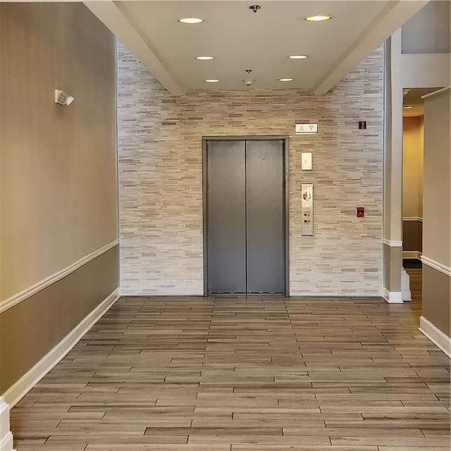 spare room featuring light wood-type flooring and elevator