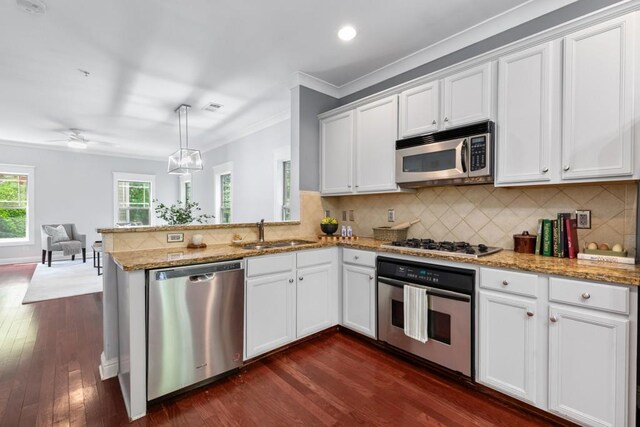 kitchen featuring white cabinets, open floor plan, appliances with stainless steel finishes, and a sink