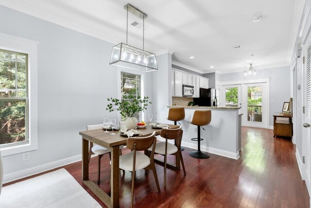 dining space with ornamental molding, baseboards, dark wood-style floors, recessed lighting, and a chandelier