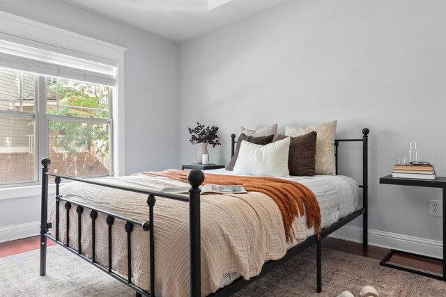bedroom with baseboards and wood finished floors