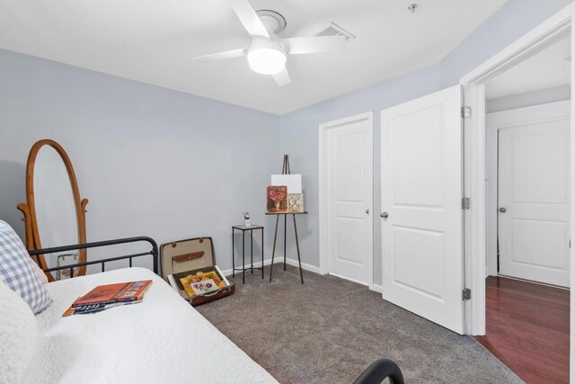 carpeted bedroom with a ceiling fan and visible vents