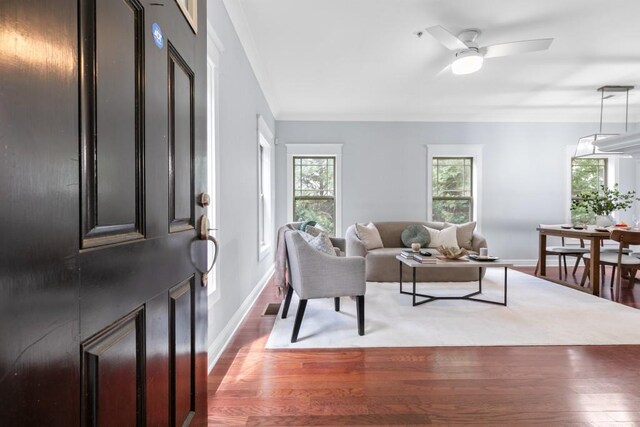 living room featuring baseboards, a ceiling fan, wood finished floors, and visible vents