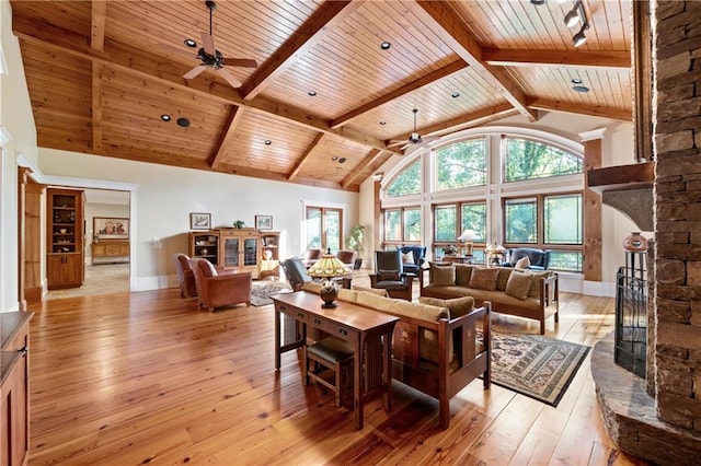 1447 Travis Smith Rd, Clarkesville, GA 30523 - living room with ceiling fan, wood ceiling with exposed beams, light wood finished floors, healthy amount of natural light, and a stone fireplace