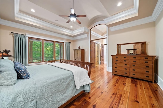 1447 Travis Smith Rd, Clarkesville, GA 30523 - bedroom featuring a tray ceiling, light wood-style flooring, ornamental molding, baseboards, and arched walkways