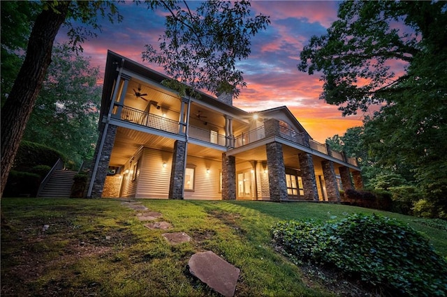 1447 Travis Smith Rd, Clarkesville, GA 30523 - rear view of house with a balcony, ceiling fan, stone siding, and a lawn