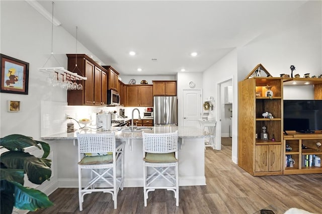 745 Skyview Dr, Commerce, GA 30529 - kitchen with appliances with stainless steel finishes, a peninsula, light stone counters, light wood finished floors, and recessed lighting