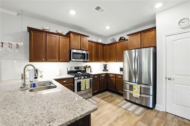 745 Skyview Dr, Commerce, GA 30529 - kitchen with stainless steel appliances, a sink, light wood-style flooring, light stone countertops, and backsplash